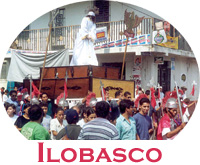 A crowded religious procession moving through the streets of Ilobasco